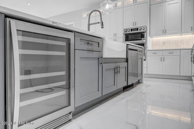 kitchen featuring decorative backsplash, beverage cooler, white cabinets, and dishwashing machine