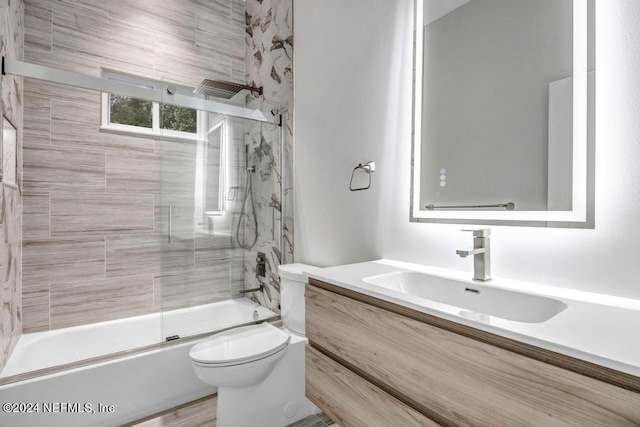 full bathroom with enclosed tub / shower combo, vanity, toilet, and hardwood / wood-style flooring