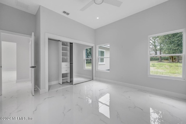 unfurnished bedroom featuring a closet, ceiling fan, and multiple windows