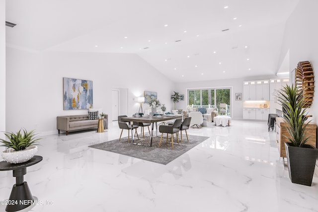 dining space featuring high vaulted ceiling