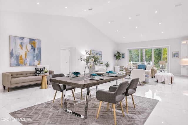 dining area with high vaulted ceiling