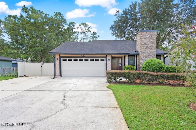 view of front of property with a garage and a front lawn