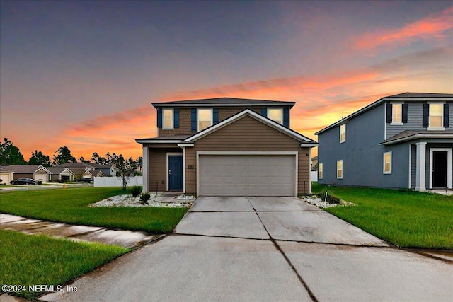 front of property with a garage and a lawn