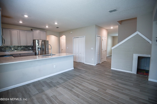 kitchen featuring gray cabinets, sink, stainless steel refrigerator with ice dispenser, decorative backsplash, and dark hardwood / wood-style flooring