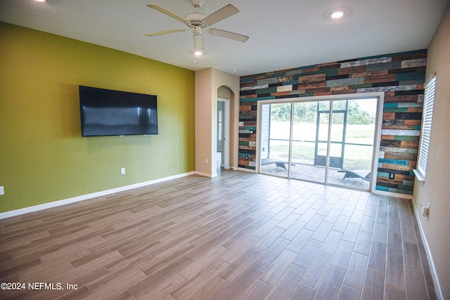 unfurnished living room featuring ceiling fan and light wood-type flooring