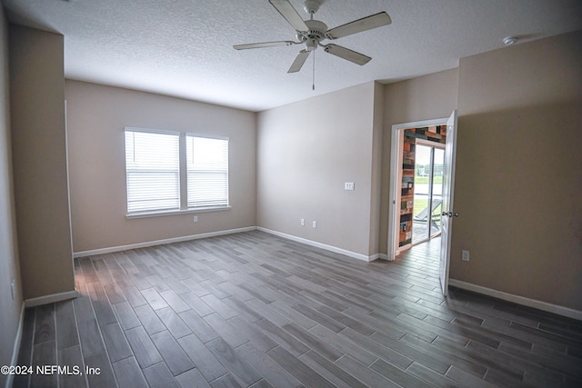 empty room with dark wood-type flooring, ceiling fan, and plenty of natural light