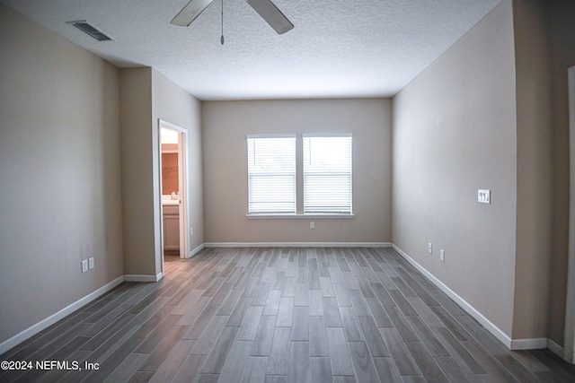 unfurnished bedroom featuring ceiling fan, dark hardwood / wood-style floors, and a textured ceiling