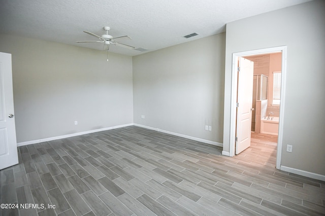 empty room featuring ceiling fan, a textured ceiling, and dark hardwood / wood-style flooring