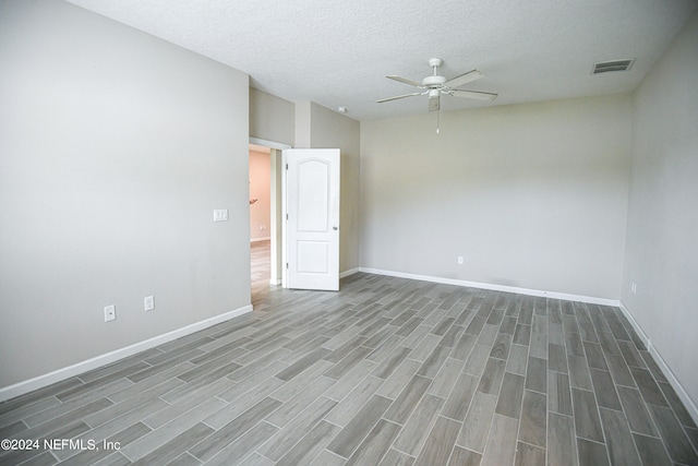 spare room with ceiling fan, a textured ceiling, and dark hardwood / wood-style flooring