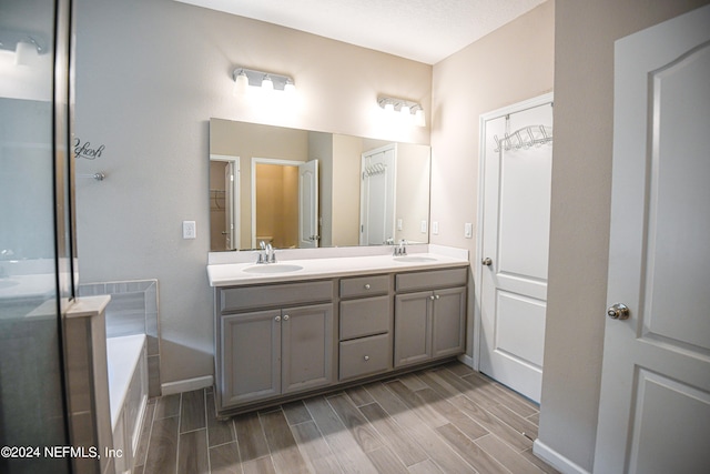 bathroom featuring hardwood / wood-style floors, a tub, and vanity