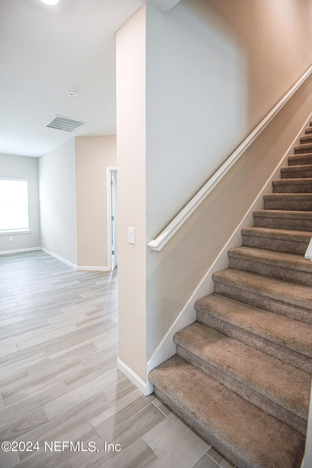 stairs featuring hardwood / wood-style flooring