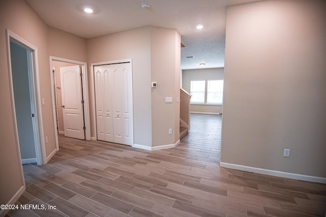 hallway featuring a textured ceiling and hardwood / wood-style floors