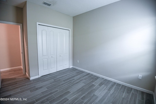 unfurnished bedroom with a closet and dark wood-type flooring