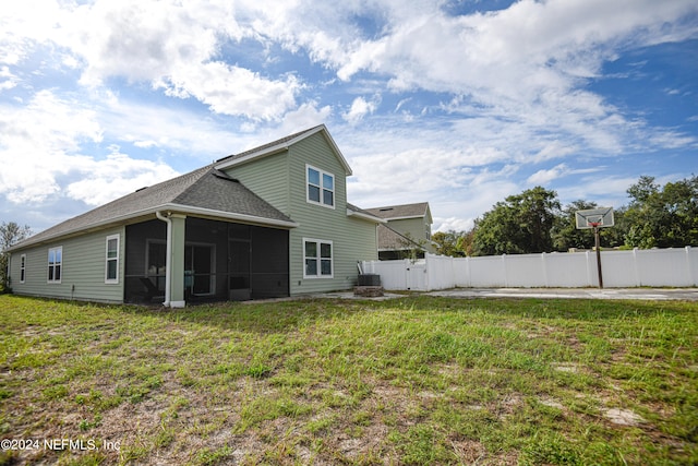 rear view of property with a sunroom, a yard, and central air condition unit