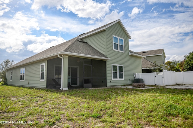 rear view of property with a sunroom, a yard, and a patio area