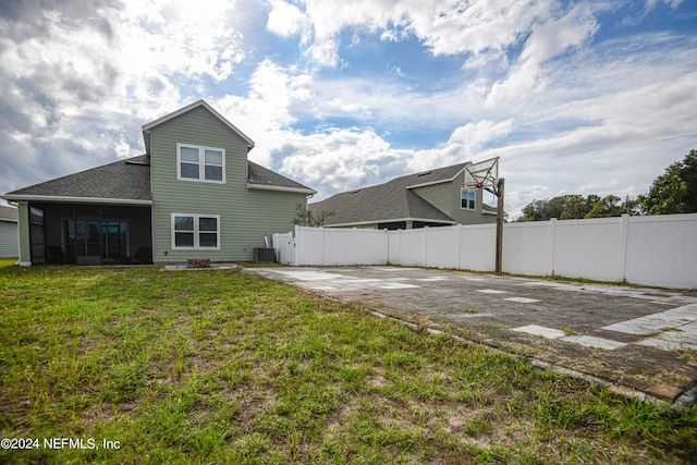 back of property with a lawn and central air condition unit