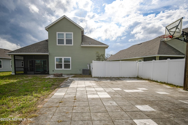 back of house with central AC unit, a lawn, and a patio