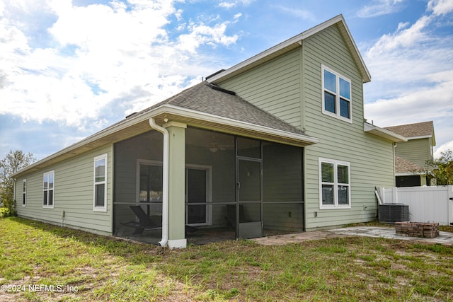 rear view of property with a sunroom, a patio, and a lawn