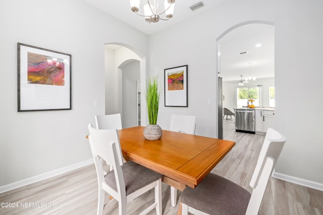 dining area featuring a chandelier and light hardwood / wood-style floors