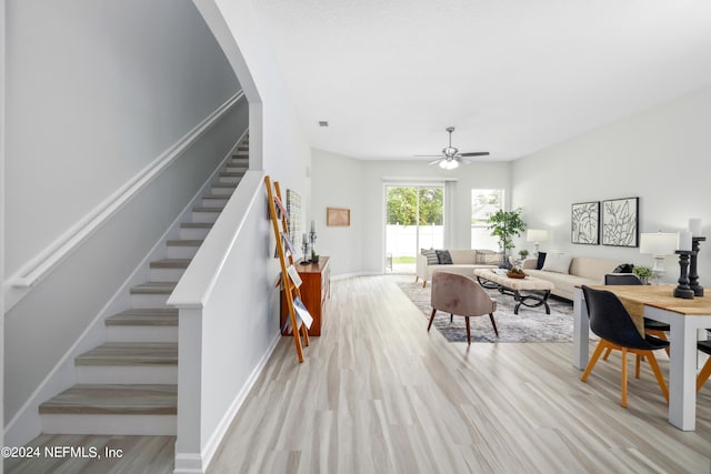 living room with light wood-type flooring and ceiling fan