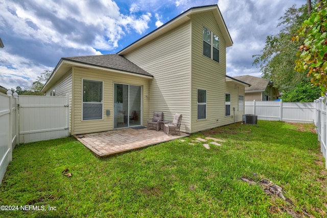 back of property with a lawn and a patio area