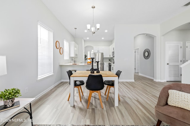 dining space featuring a notable chandelier and light wood-type flooring