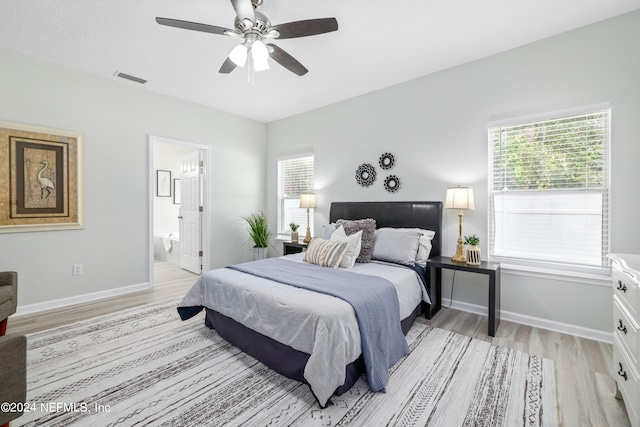 bedroom with ceiling fan, light hardwood / wood-style flooring, and ensuite bath