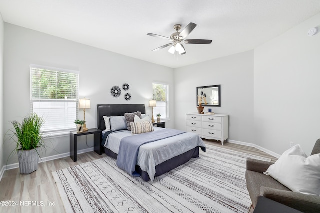 bedroom with multiple windows, light wood-type flooring, and ceiling fan