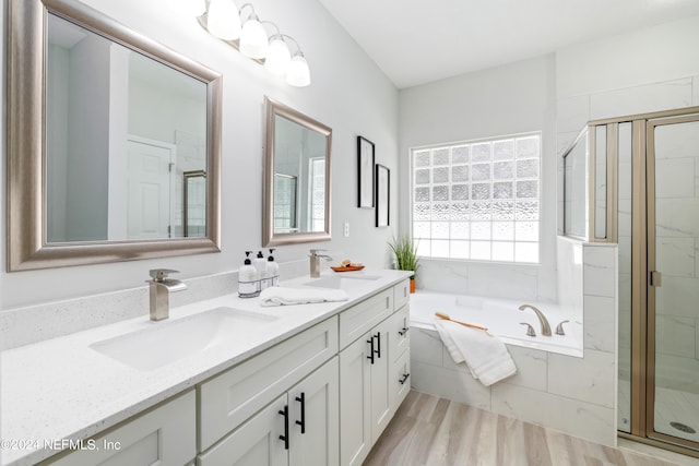 bathroom with plus walk in shower, wood-type flooring, and vanity