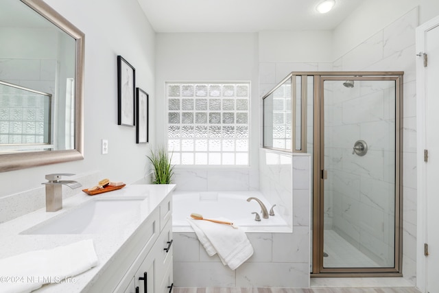 bathroom with plus walk in shower, plenty of natural light, and vanity