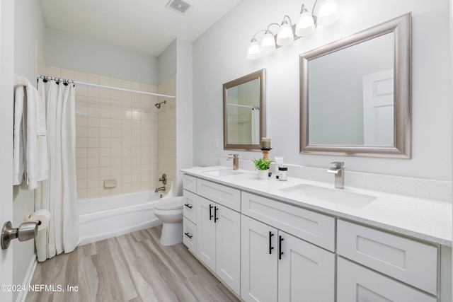 full bathroom featuring vanity, hardwood / wood-style flooring, shower / tub combo, and toilet