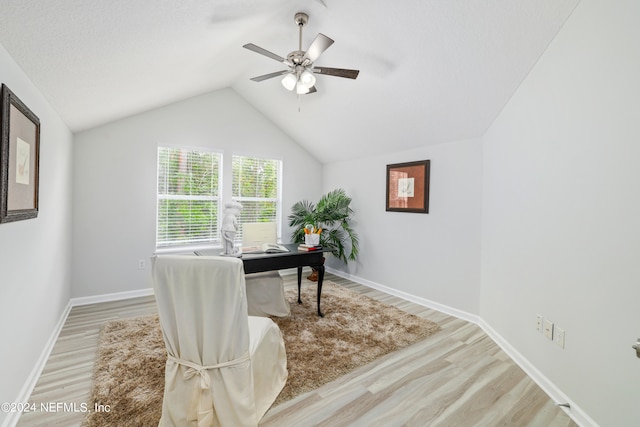 home office featuring ceiling fan, light hardwood / wood-style floors, and vaulted ceiling