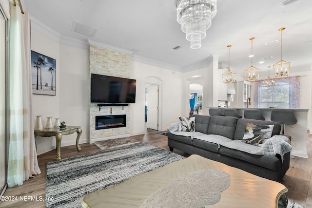 living room with ornamental molding, wood-type flooring, and a fireplace