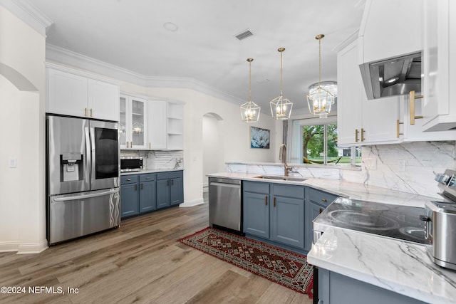 kitchen featuring sink, white cabinetry, decorative backsplash, appliances with stainless steel finishes, and decorative light fixtures