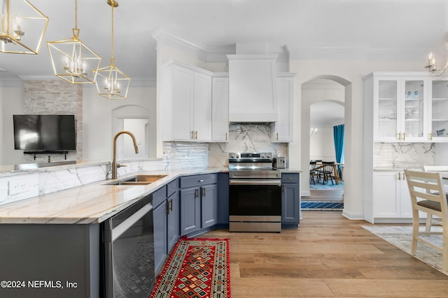 kitchen featuring white cabinets, sink, light hardwood / wood-style flooring, backsplash, and stainless steel appliances