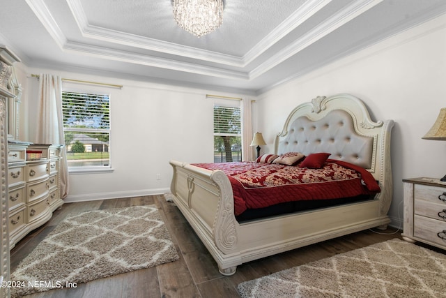 bedroom with crown molding, a tray ceiling, and dark hardwood / wood-style flooring