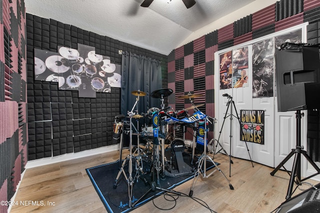 rec room with vaulted ceiling, ceiling fan, hardwood / wood-style floors, and a textured ceiling