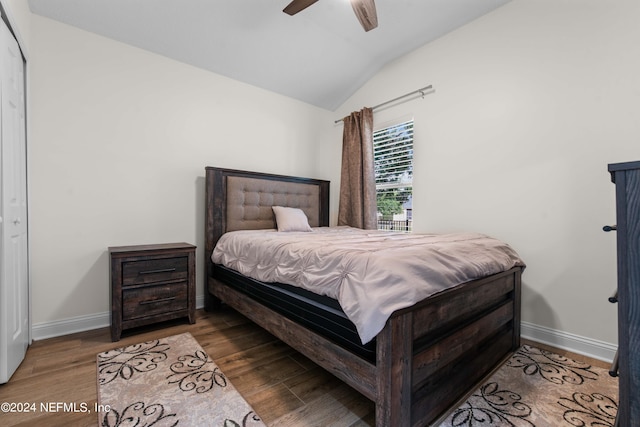 bedroom with vaulted ceiling, hardwood / wood-style floors, ceiling fan, and a closet