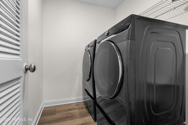 washroom featuring dark hardwood / wood-style floors and washer and clothes dryer