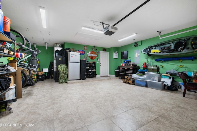 garage with a garage door opener and white fridge