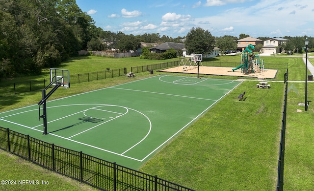 view of basketball court featuring a lawn and a playground