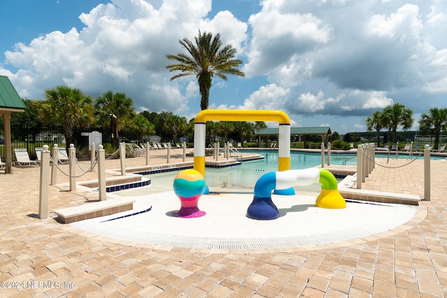 view of playground with a community pool and a patio