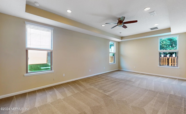 carpeted empty room featuring ceiling fan, a textured ceiling, and plenty of natural light