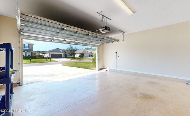 garage featuring a lawn, a garage door opener, and a carport