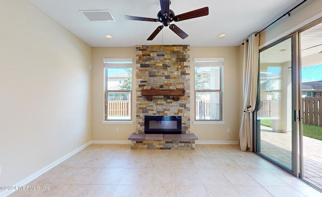 unfurnished living room with a fireplace, light tile patterned flooring, and ceiling fan