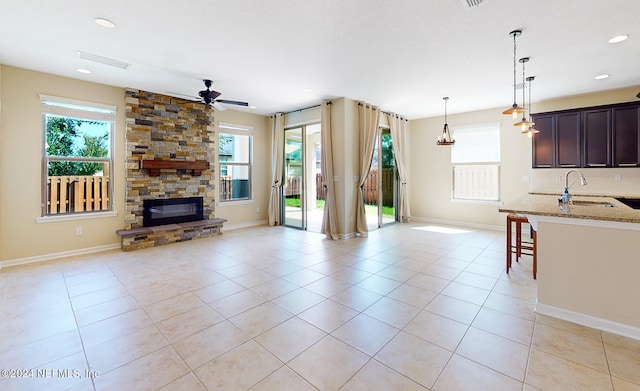 unfurnished living room featuring sink, light tile patterned floors, and plenty of natural light