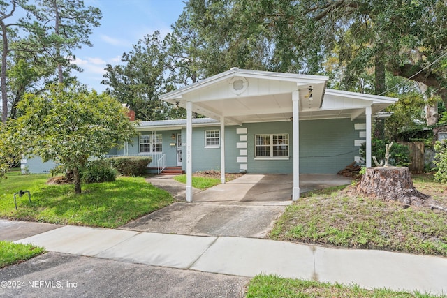 view of front of property featuring a carport, covered porch, and a front yard