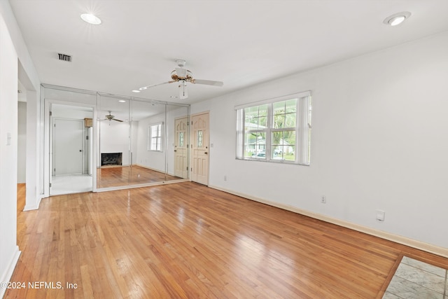 unfurnished living room with ceiling fan and light wood-type flooring