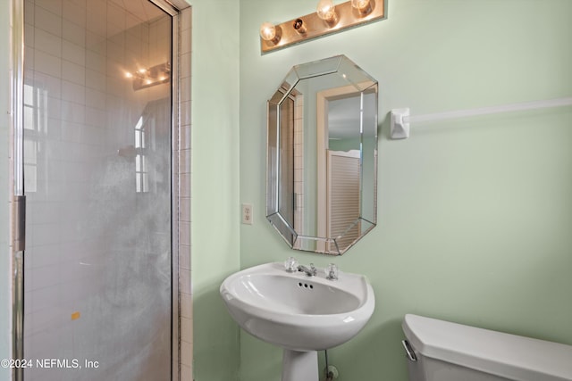 bathroom featuring sink, toilet, and an enclosed shower