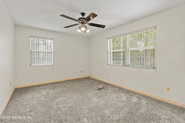 unfurnished room with ceiling fan, carpet flooring, and a wealth of natural light